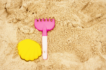 Fototapeta na wymiar colorful mold and rake on the sand on the beach in summer