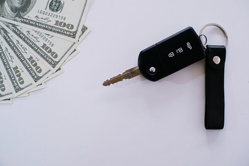 Car key on 100 dollar with white background.