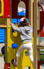 Little children run around and play in the playground. Game center for a young child. Little girl is playing outdoors. The concept of summer children's entertainment.