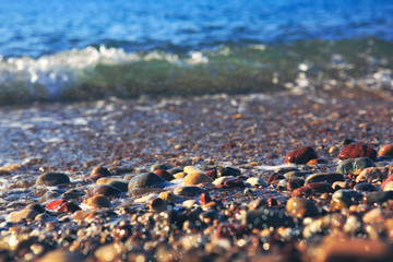Waves washing over gravel beach, macro shot.