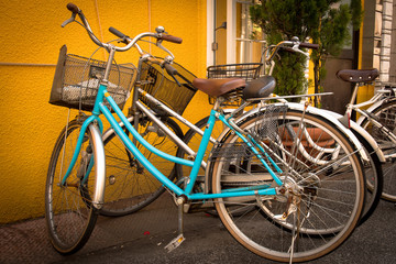 A blue and silver bicycle in front of a colorful orange wall
