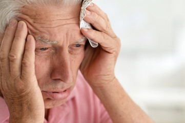 Fototapeta premium Close up portrait of senior man with headache
