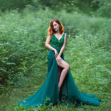 a red hair witch in green dress with long train