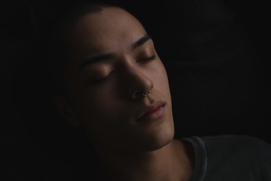 Close up of androgynous young man sleeping at home