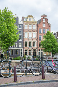 Biciclette in primo piano e palazzi caratteristici di Amsterdam sullo sfondo