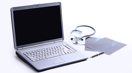 laptop ,stethoscope and x-ray on the table