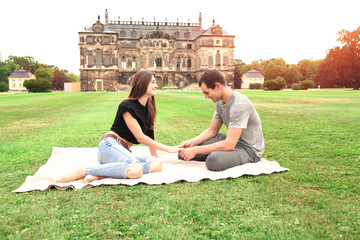 Young couple sitting in front of Historic Building