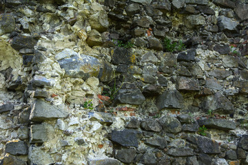 An old faded stone in the cracked weathered and shattered wall of a once majestic castle. In the category of creative background of exotic summer holidays, screen saver, wallpaper.