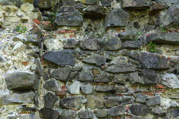 An old faded stone in the cracked weathered and shattered wall of a once majestic castle. In the category of creative background of exotic summer holidays, screen saver, wallpaper.