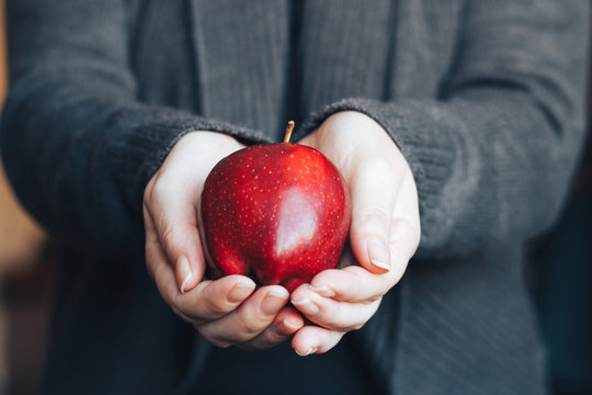 Woman Holding A Red Apple In Her Hands