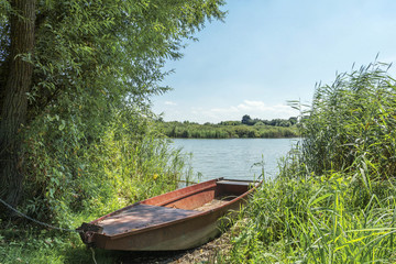 Naklejka na ściany i meble Lake landscape with metal fishing boat