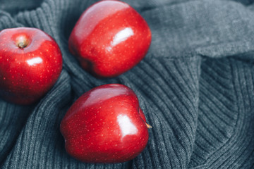 Red apples on gray woolen background