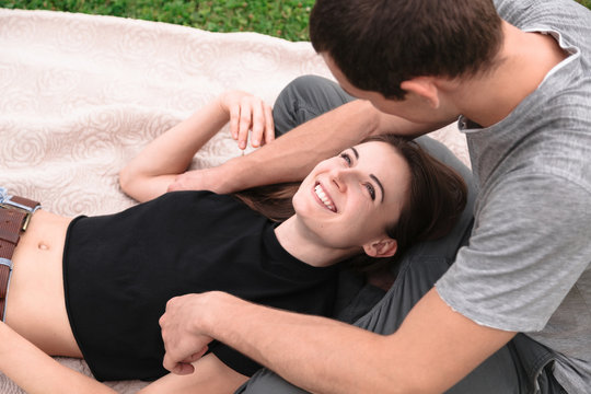 Young beautiful couple on blanket on grass