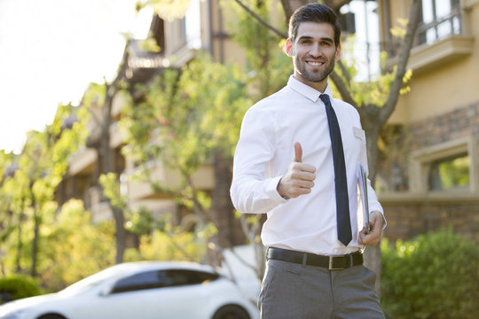 Confident businessman doing thumbs up