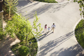 Happy young family holding hands walking