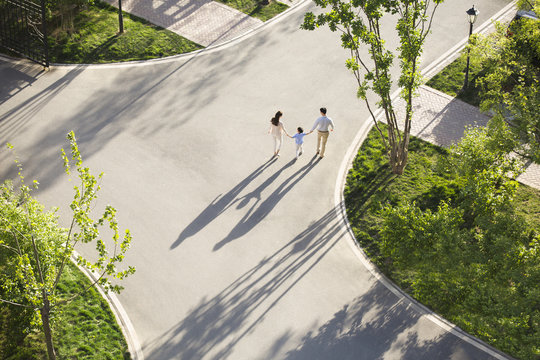 Happy young family holding hands walking