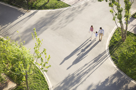 Happy young family holding hands walking