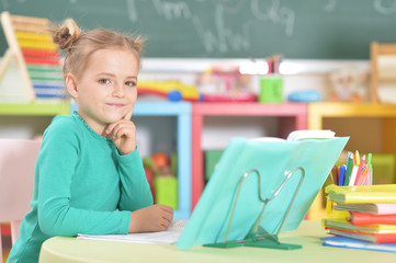 Portrait of a cute schoolgirl doing homework