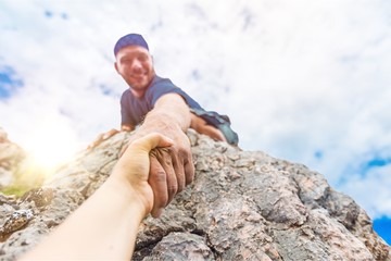 Adventurers helping each other to climb