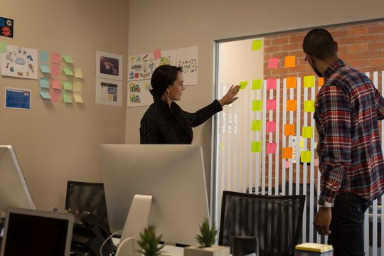 Business colleagues discussing over sticky notes