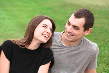 Fototapeta premium Beautiful couple sit on a blanket on the grass