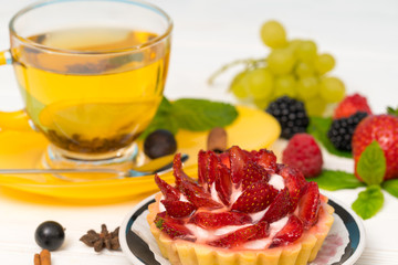 Strawberry tart served with herbal tea and fruits