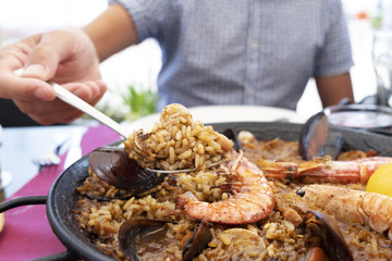 man serving a typical spanish seafood paella