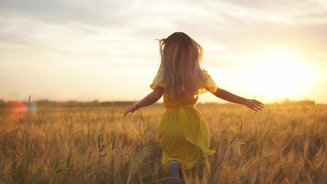Girl running across field in the sunset