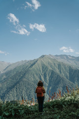 Fototapeta na wymiar Woman traveler hipster with backpack looking forward at amazing mountains and valley view