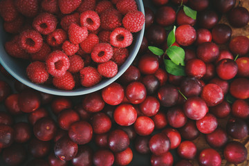 Raspberries and plums on a black table. Berries and fruit. 