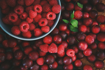 Raspberries and plums on a black table. Berries and fruit. 