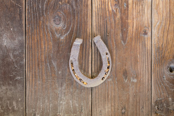 A rusty horseshoe fixed on old farm wal