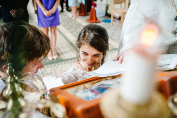 Newlyweds, couple happy at the wedding ceremony in the church. The priest blesses the holy icon for...