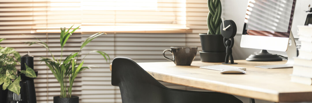 Coffee Cup, Creative Clock And A Desktop Computer On A Wooden Desk In A Sunny Workspace Interior With Plants