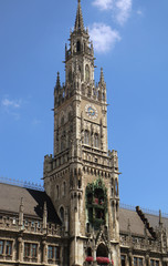 Fototapeta na wymiar Munich Germany - the clock tower of the new City Hall in Marienplatz richly decorated in Gothic Revival architecture and the Glockenspiel with the medieval life-size figures