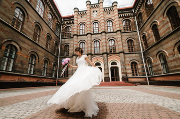 Obraz premium Beautiful portrait bride are dancing and spinning back near ancient restored architecture, old building, old house outside, vintage palace outdoor.