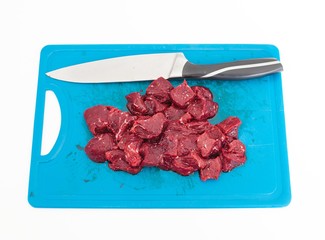 Whale row meat cut into the cubes on the cutting board with knife. Isolated in white background.