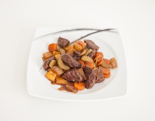 Whale stew with vegetables dish on the plate in white background