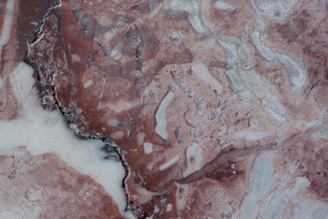 Fototapeta premium Reddish brown structure with fractures and gray spots. Natural material. Classic travertine texture.