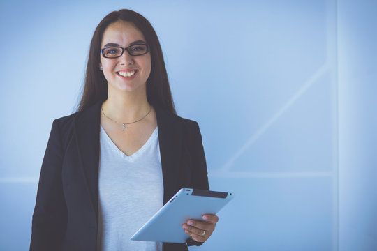 Portrait of smiling young business woman with digital tablet in her hands