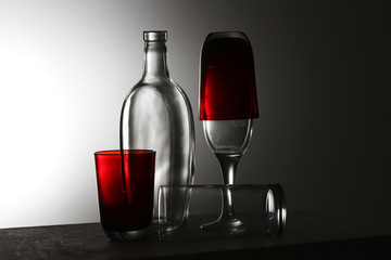 A transparent bottle and red glasses