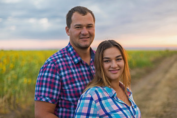 Young romantic couple in a field of sunflowers, pregnant girl in sunflowers