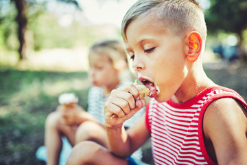 Kids eating ice cream on hot summer day on tropical vacation.