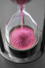 Pink sand falling in hourglass - selective colored