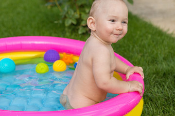 A small child is bathing in a pool, inflatable children's inflatable pool in summer