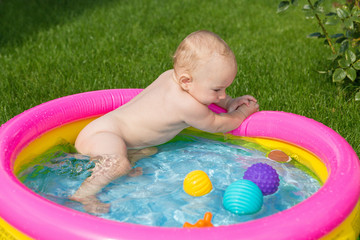 A small child is bathing in a pool, inflatable children's inflatable pool in summer