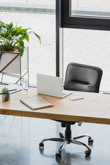 laptop and smartphone on wooden table in modern office
