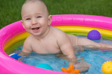 A small child is bathing in a pool, inflatable children's inflatable pool in summer