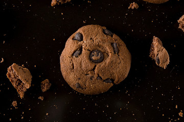 Sweet cookies with chocolate on black background