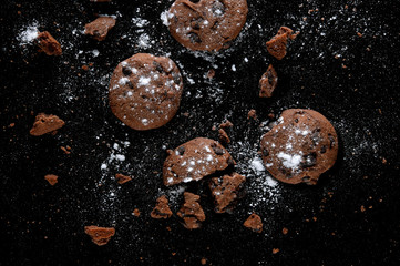 Sweet cookies with chocolate on black background
